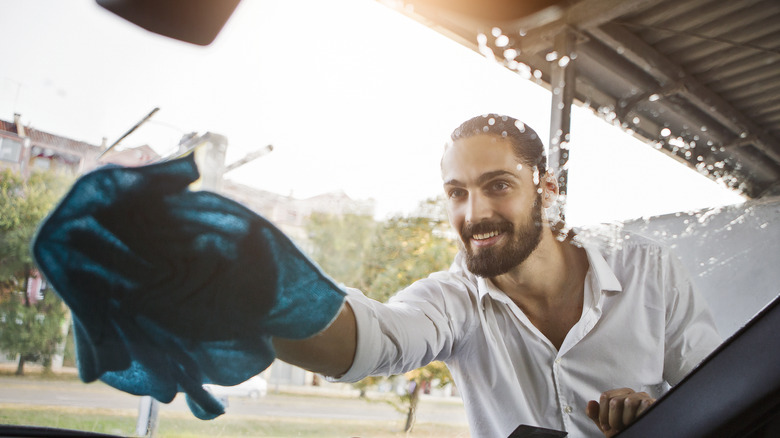 person cleaning car windshield