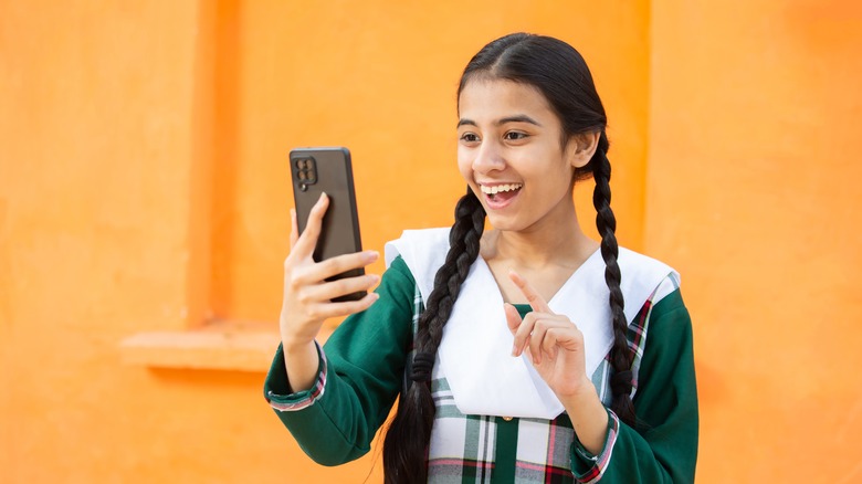 girl smiling at phone