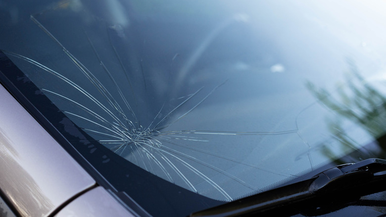 Multiple cracks in a windshield's bottom left corner