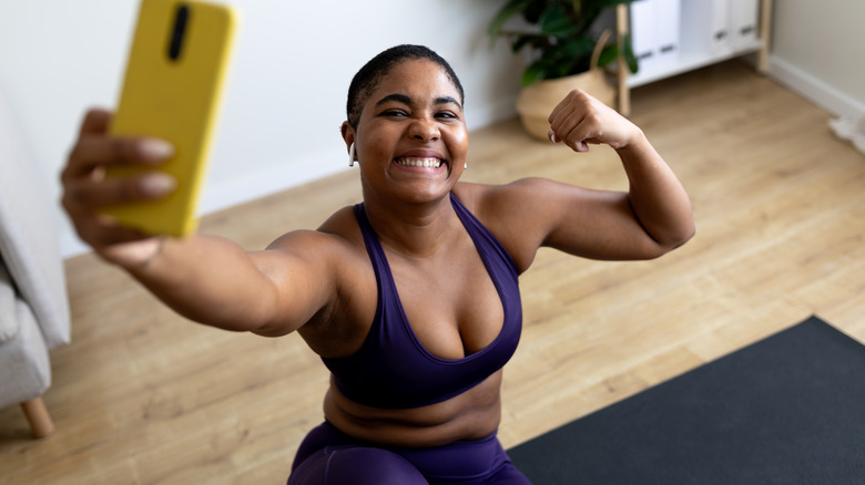 woman wearing airpods taking gym selfie