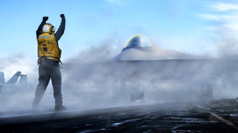 An artist's rendering of the Boeing F/A-XX shrouded in smoke on an aircraft carrier