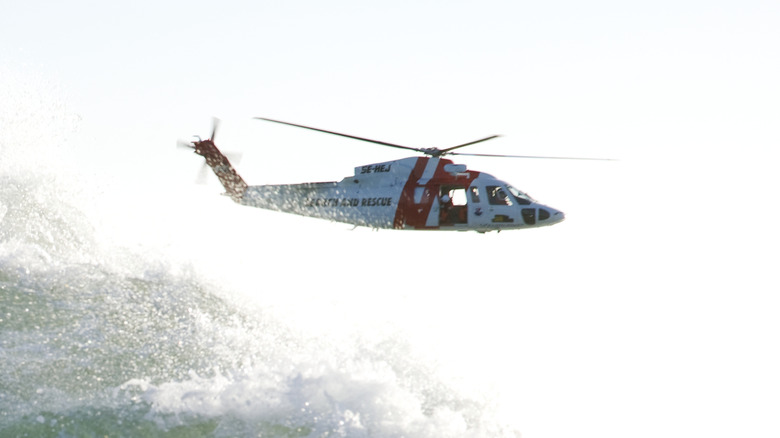 An MH-60 Seahawk helicopter flying low over waves