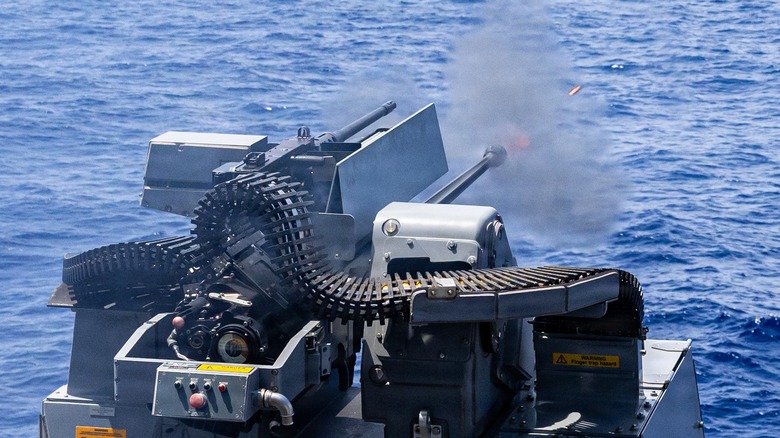 A Mark 38 Mod 4 30mm defense system mounted on the USS Mustin firing its main gun