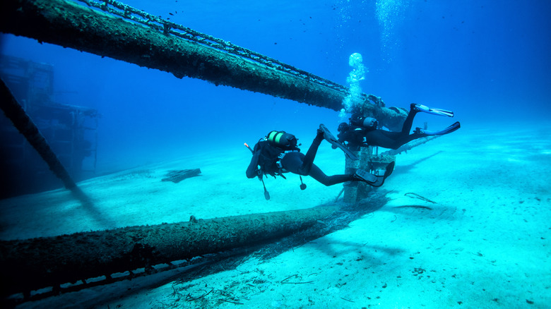 Two scuba divers inspecting an undersea pipeline