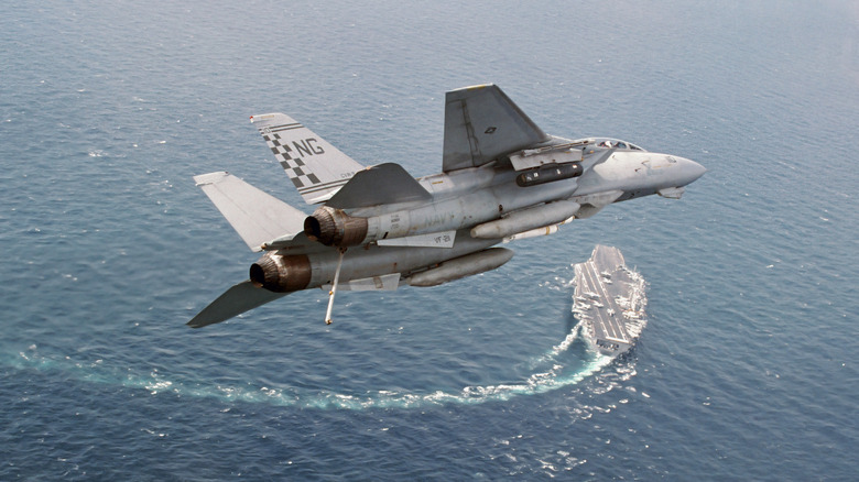 F-14 Tomcat flying over the USS Nimitz