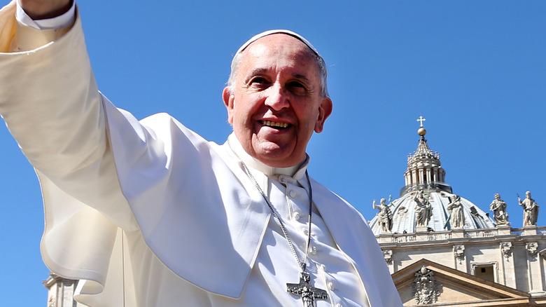 Pope Francis waving at people.