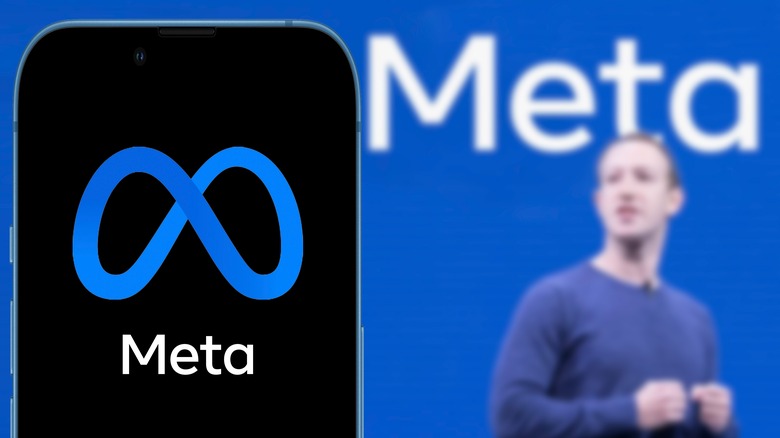 Mark Zuckerberg behind phone with meta screen