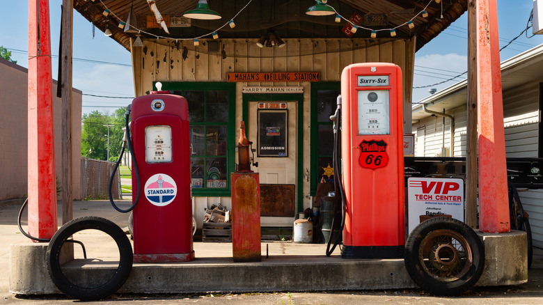 Multiple old gas pumps set up outside.