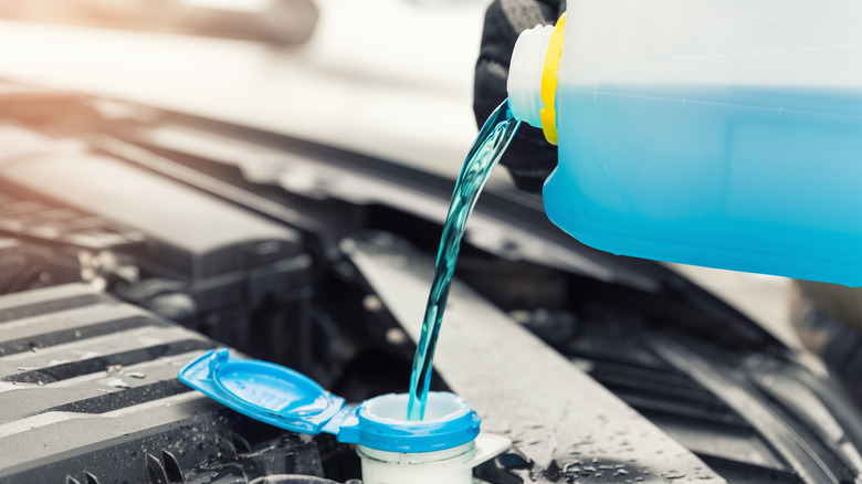 Pouring windshield washer fluid being poured in