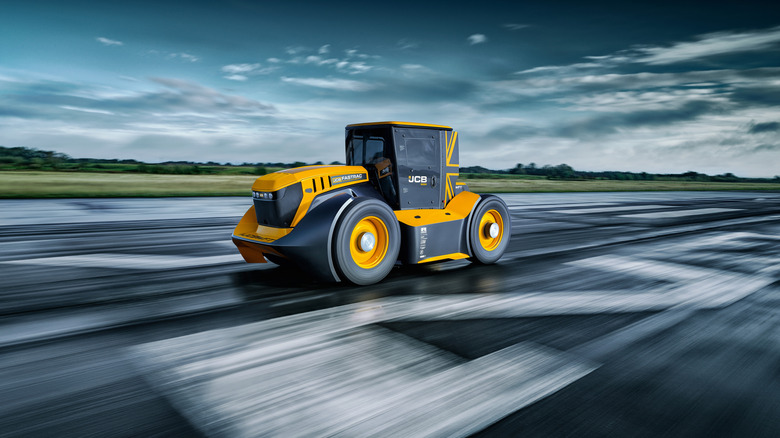 Blurred image of a runway, with an in-focus yellow JCB Fastrac Two tractor