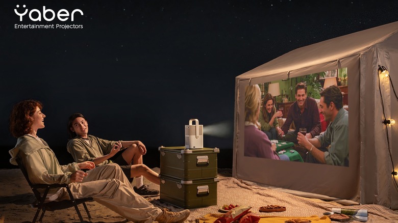 Campers watching Yaber projector on side of tent