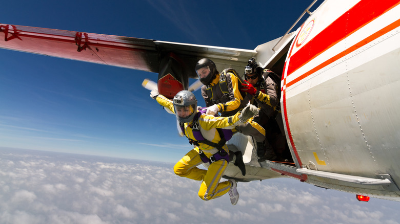 Two parachutists leaping from the rear door of an aircraft