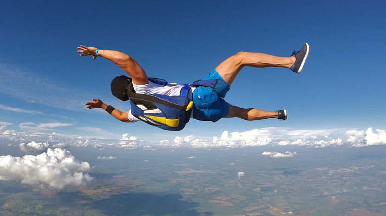 Free falling parachutist wearing shorts, t-shirt, and casual shoes.
