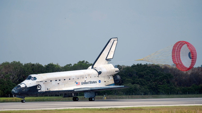 Space Shuttle Discovery landing with braking parachute deployed