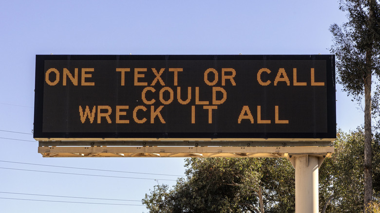 A CMS above a roadway with a rhyming message.