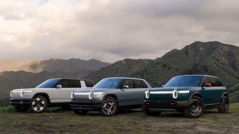 Three Rivian models parked off-road in mountainous terrain