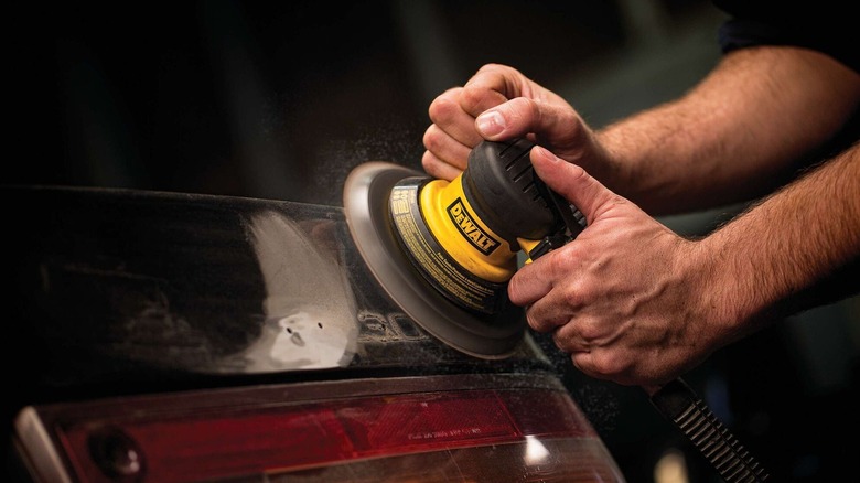 Person using a DeWalt palm sander