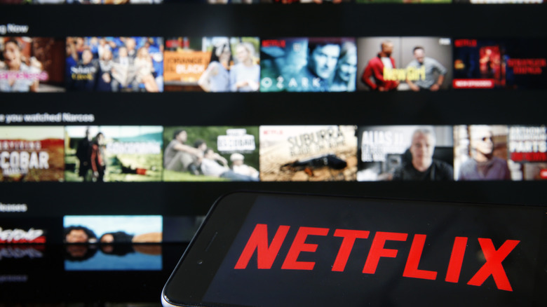 Logotipo da Netflix no iPhone, TV UI em segundo plano