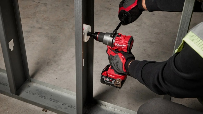 Person using Milwaukee hammer drill