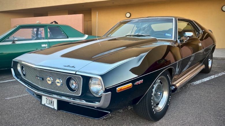 Black and white 1971 AMC Javelin AMX in a parking lot next to a green car
