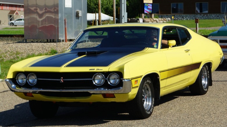 Yellow and black 1971 Ford Torino Cobra on a small-town road