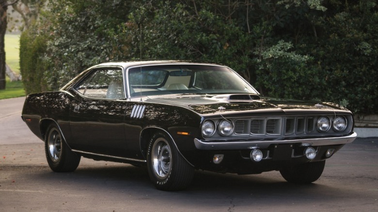 Black 1971 Plymouth HEMI 'Cuda parked on a leafy suburban road