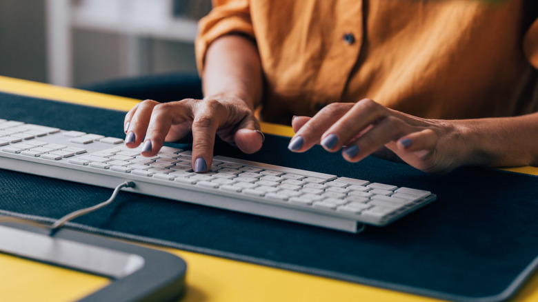 woman typing on a mac keyboard