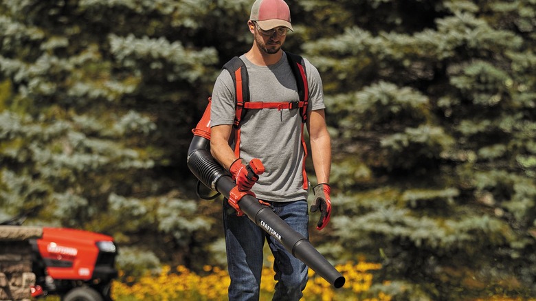 A person using a Craftsman backpack blower outside.