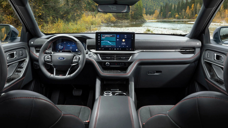 View from the second row of a 2025 Ford Explorer including interior and forest and river scene outside