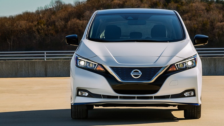 Head-on photo of a white Nissan Leaf in a parking lot