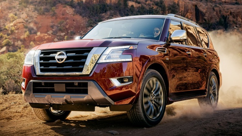 Red Nissan Armada driving on a dirt road