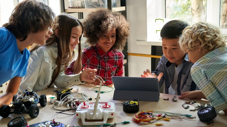 five grade school kids working on electronics