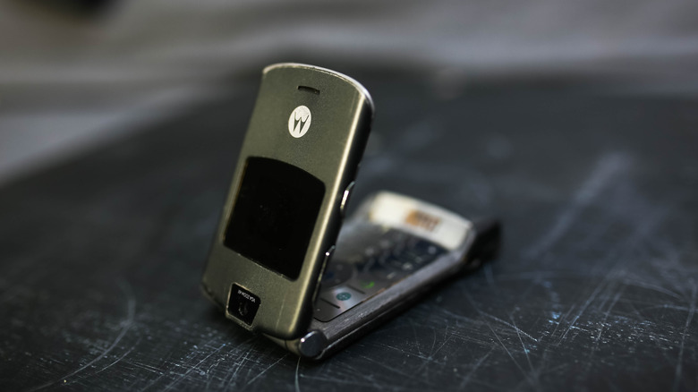 The Motorola Razr V3 on a scratched black table.