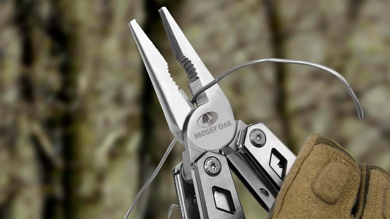 Person cutting wire with a Mossy Oak 21-in-1