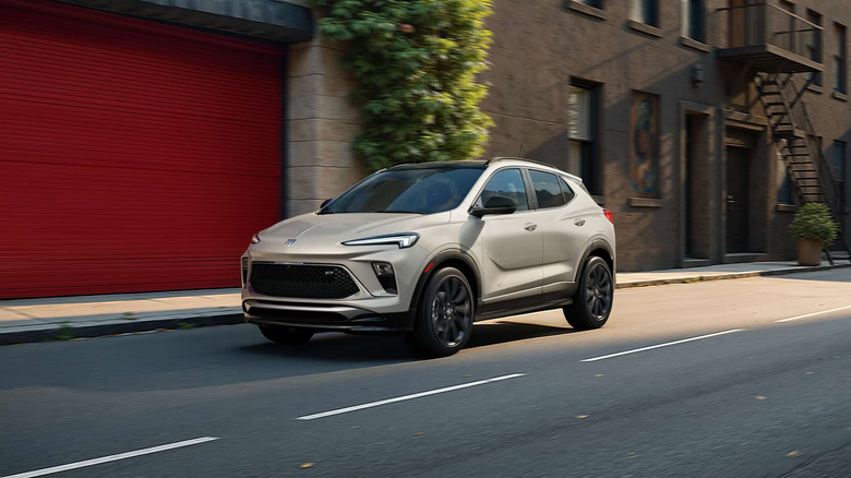 A light beige 2026 Buick Encore GX driving down a street