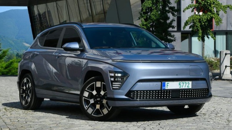 A gray Hyundai Kona Electric parked in front of a building