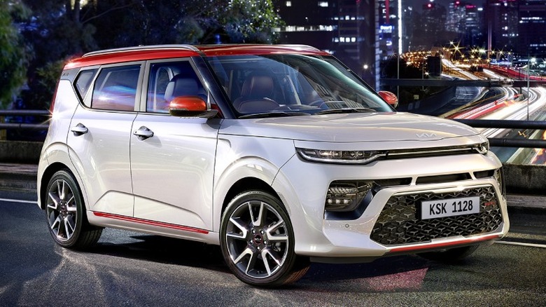 A white Kia Soul parked on a city steet at night