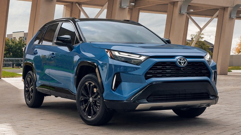 A blue 2025 Toyota RAV4 Hybrid parked underneath a cement structure.