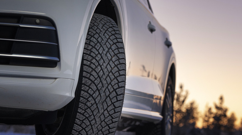 Front 3/4 view of Nokian Tyres Hakkapeliitta R5 on front of SUV in wooded setting