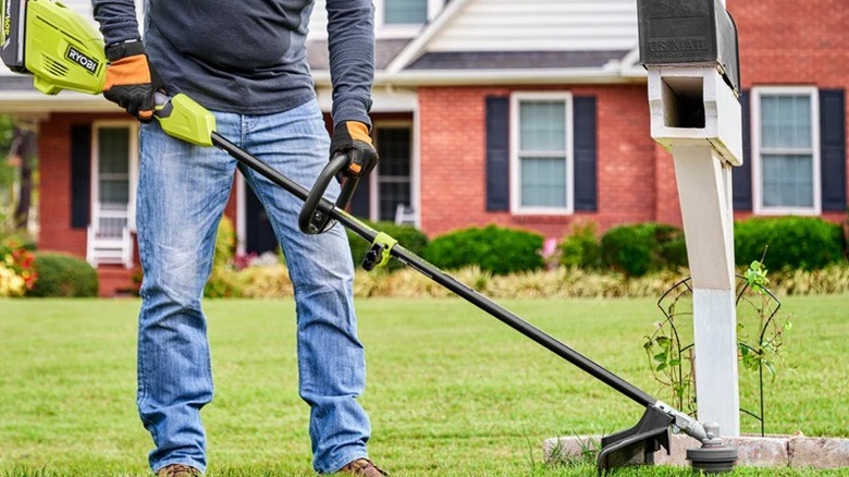 Person using Ryobi string trimmer