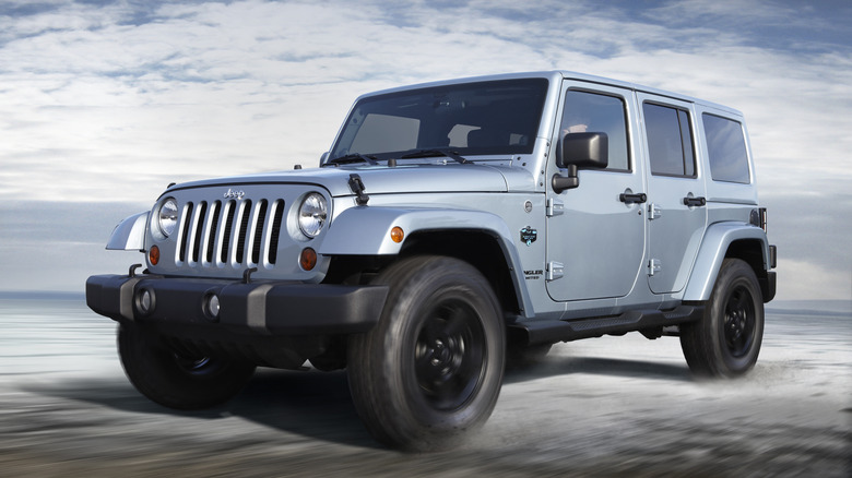 A 2012 Jeep Wrangler on the move in a desert, front 3/4 view