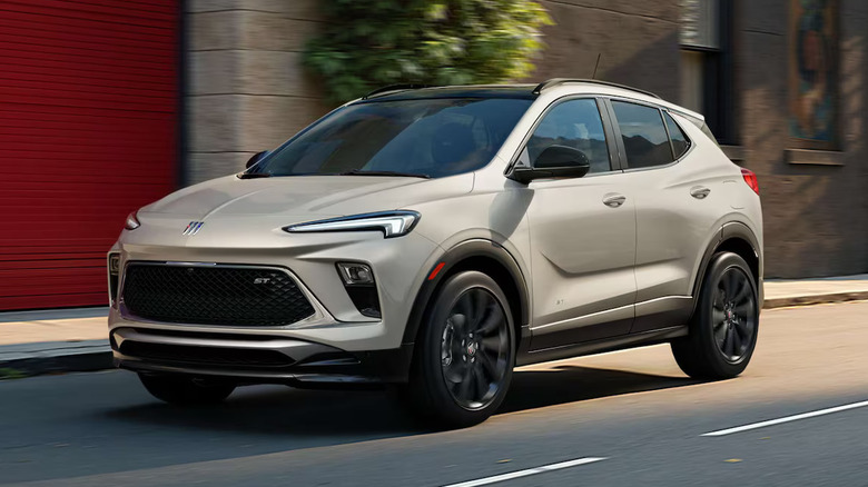 Beige Buick Encore GX driving on an urban street