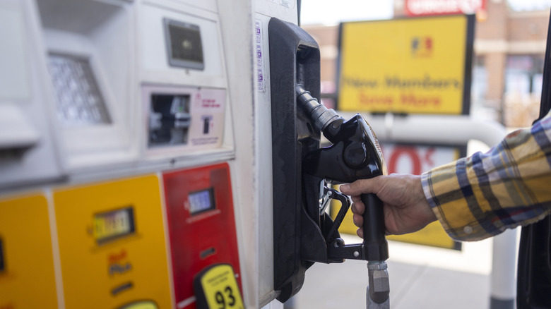 Man putting gas pump back in place
