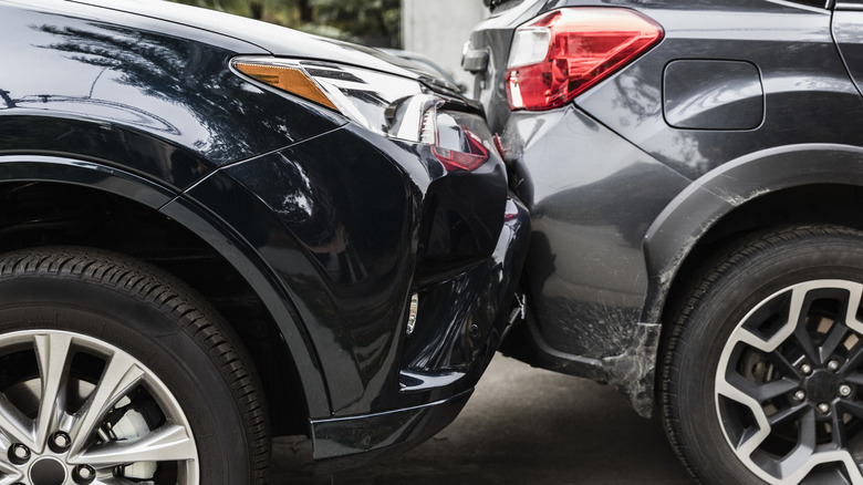 Black and gray cars involved in a collision.