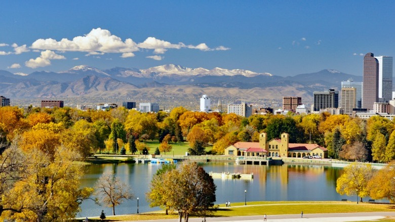 A park in Denver, Colorado in autumn, with buildings and mountains in the distance