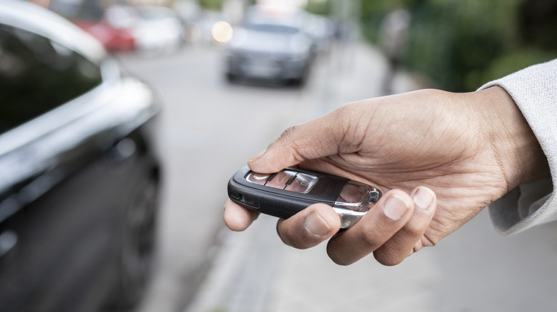 Close-up of a hand locking a vehicle using a remote