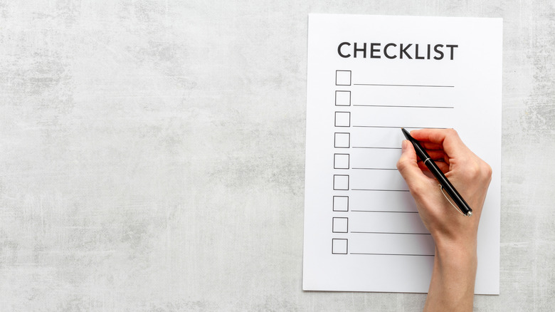 Hand with a pen on a checklist