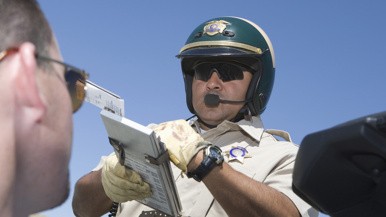 A police officer writing up a ticket for a motorist
