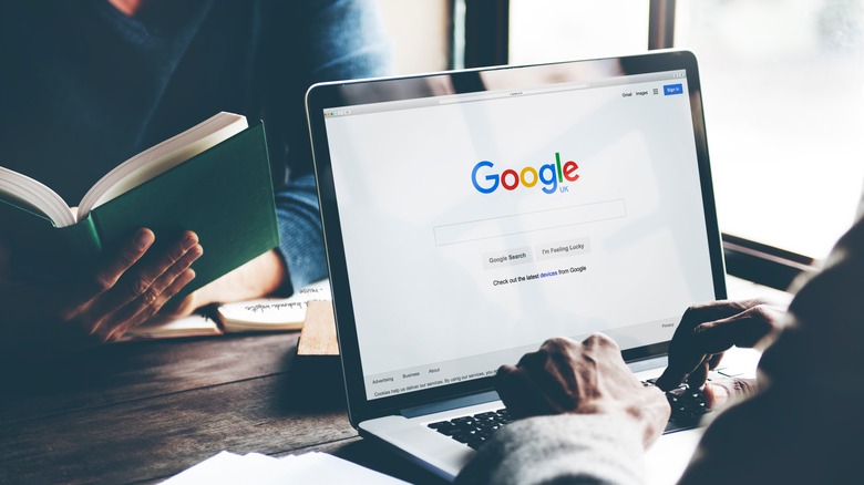 Man Using Laptop Browsing Google Website