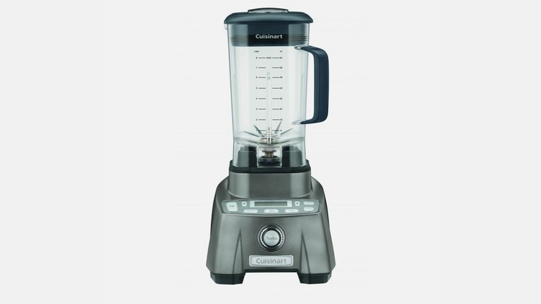 Blender on a kitchen counter containing a pink smoothie